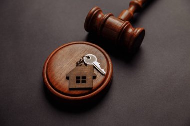 Judge gavel and key chain in shape of two splitted part of house on wooden background. Concept of real estate auction or dividing house when divorce, division of property, real estate, law system clipart