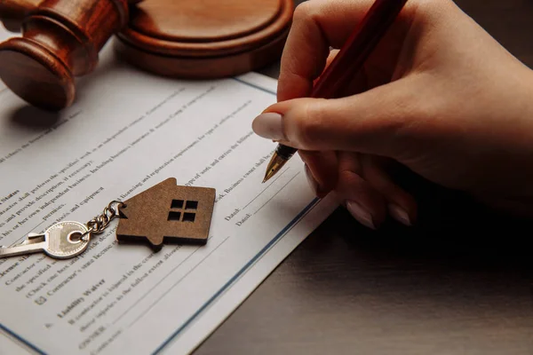 House keys and money on a signed contract of house sale. Focus on keys.