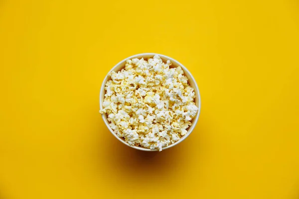 Popcorn shora na žlutém pozadí. Plochá mísa popcornu. Horní pohled — Stock fotografie