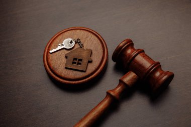 Yargıç Tokmak ve anahtarlık ahşap arka planda iki parçalı ev şeklinde. Boşanma, mal paylaşımı, gayrimenkul, hukuk sistemi...