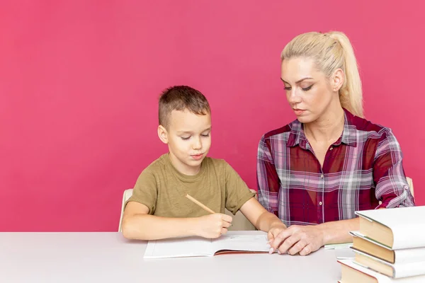 距離教育を一緒に。息子と一緒に家で宿題をするお母さん. — ストック写真