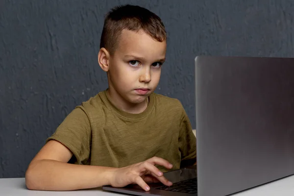 Thuis leren in quarantaine. Droevige jongen zit in de kamer naast de laptop. — Stockfoto