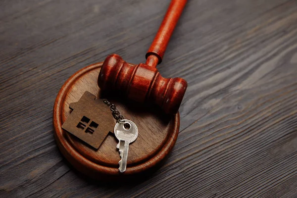 Judge gavel and key chain in shape of two splitted part of house on wooden background. Concept of real estate auction or dividing house when divorce, division of property, real estate, law system — Stock Photo, Image