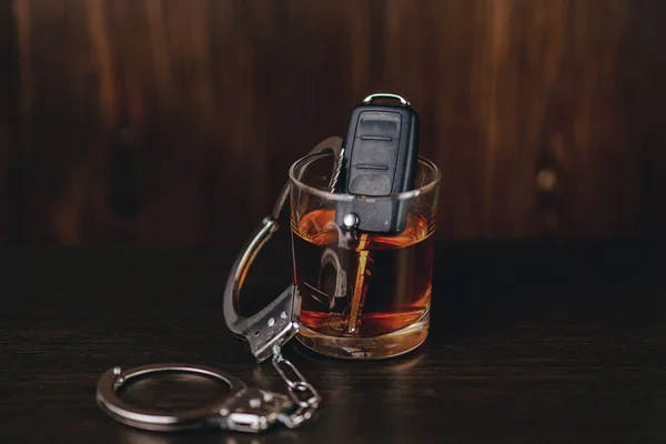 Whiskey with car keys and handcuffs. Concept for drinking and driving — Stock Photo, Image