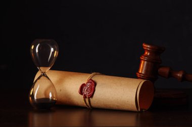 Hourglass, wooden gavel and testament and last will on wooden table in notary office clipart