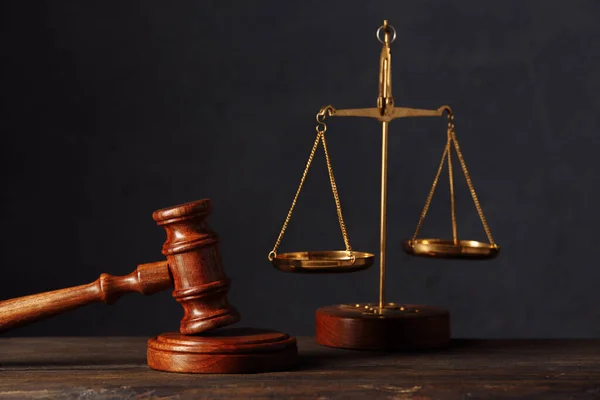 法律和司法概念。律师服务台。法官槌，天平，木制桌子。深灰色波克背景 — 图库照片
