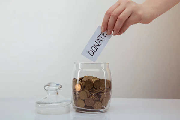 Donation concept. Womans hand putting coin in the money box. — Stock Photo, Image