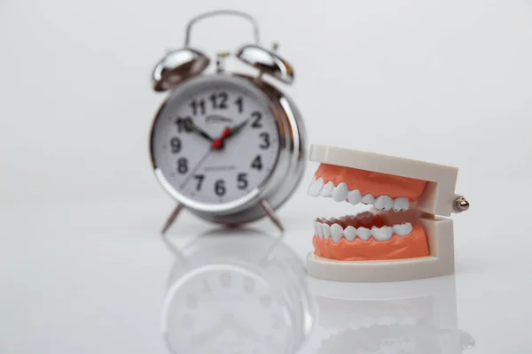 Dente de papel branco com despertador no fundo azul. Tempo para a saúde dentária. Conceito de dia de dentista. Flat lay, vista superior, espaço de cópia para texto . — Fotografia de Stock