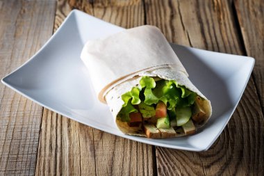 Vejetaryen rulo Suluguni peynir, salata ve domates, tabak tabak ve malzemeler üzerinde