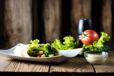 Vejetaryen rulo Suluguni peynir, salata ve domates, tabak tabak ve malzemeler üzerinde