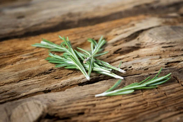 Sprigs of rosemary on wooden background — Stock Photo, Image