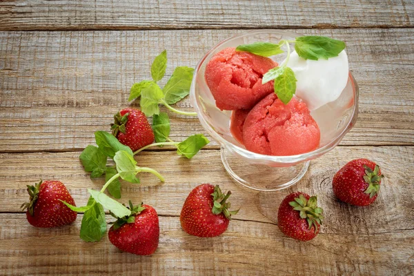 strawberry sorbet and sprigs of mint on wooden background