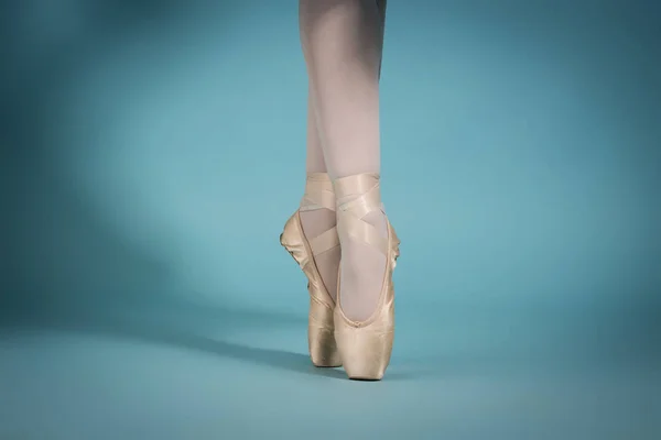Pés menina bailarina no dedo do pé sapatos no fundo turquesa — Fotografia de Stock