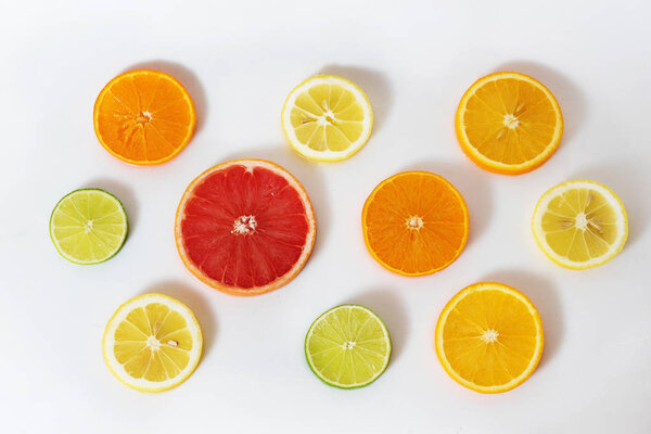 round slices of citrus fruits on white background