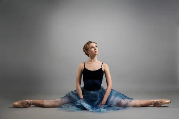 Linda menina bailarina dançando em uma saia azul exuberante no fundo cinza no estúdio — Fotografia de Stock