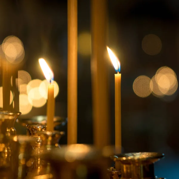 bir kilisede mum bulanık bokeh ile karanlık bir arka plan üzerinde iki yanan mumlar