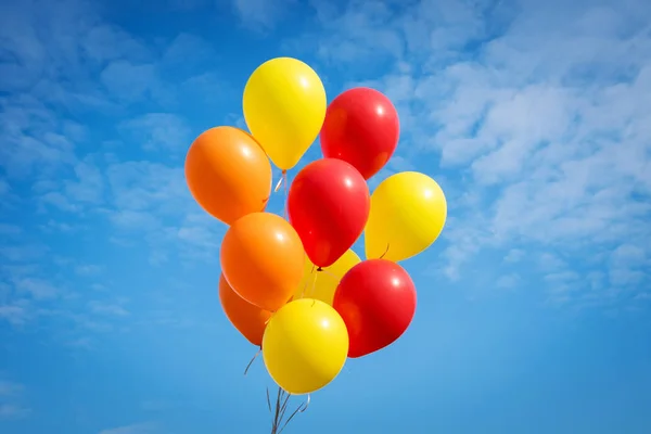 Globos amarillos y rojos sobre un fondo azul del cielo —  Fotos de Stock