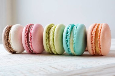 ahşap arka plan üzerinde üst üste macaroons renkli kek, yalan