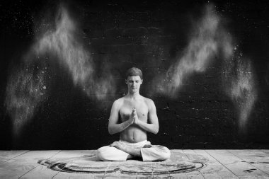 Karanlık bir odada beyaz bulutu Yoga yapan bir erkek. Lotus pozisyonda oturan, eller meme Namaste önünde katlanmış. arka kanatlarını. Enerji kavramı. Siyah-beyaz fotoğraf.