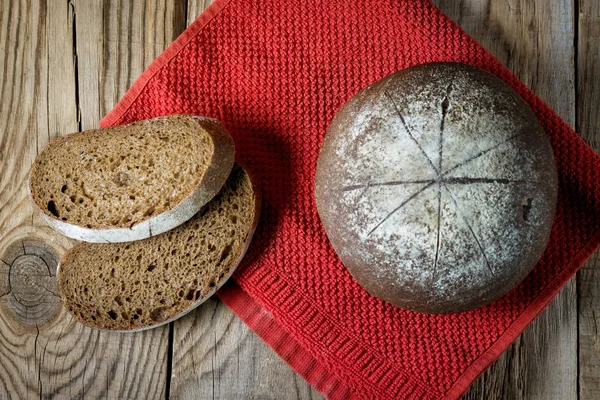 kırmızı kumaş peçete ahşap arka plan üzerinde siyah yuvarlak rustik ekmek