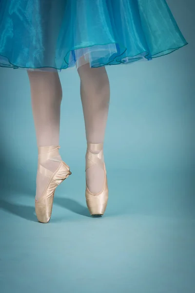 Pés da bailarina em sapatos de dedo do pé no fundo turquesa — Fotografia de Stock