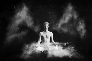 Karanlık bir odada beyaz bulutu Yoga yapan bir erkek. Enerji kavramı. Siyah-beyaz fotoğraf. Lotus bulunduğu levitating