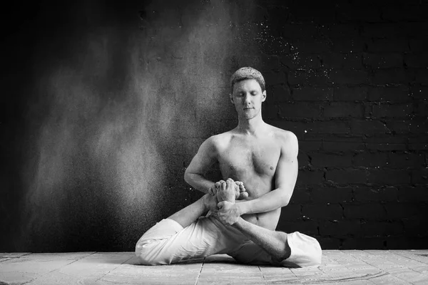 Um homem fazendo ioga em uma nuvem branca de poeira em uma sala escura. O conceito de energia. Foto em preto e branco. Vamadevasana ou II Dose do sábio Vamadeva — Fotografia de Stock