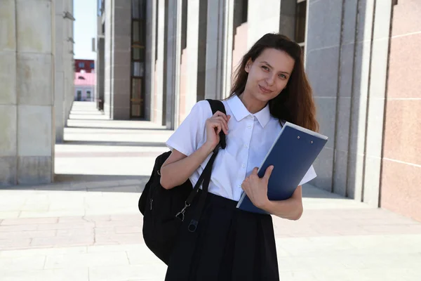 Étudiante tenant un dossier entre les mains, étudiante, une école , Photo De Stock