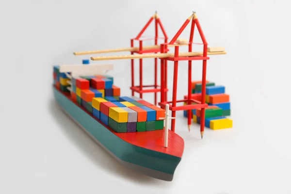 Bespotten schip op witte achtergrond, gekleurde containers, houten speelgoed, Rechtenvrije Stockfoto's