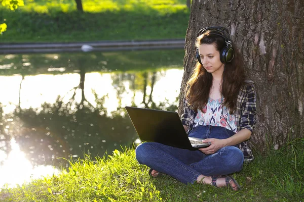 Meisje in de hoofdtelefoon in het park, zonsondergang, Rechtenvrije Stockafbeeldingen