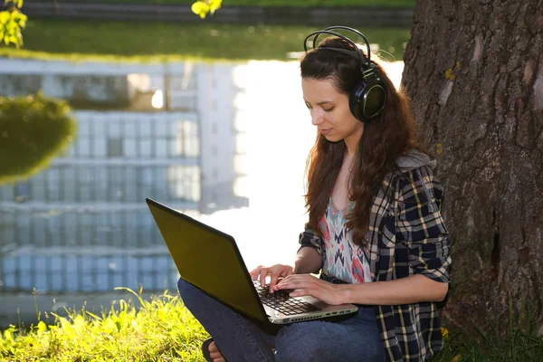 Menina em fones de ouvido no parque, pôr do sol , Imagens De Bancos De Imagens Sem Royalties