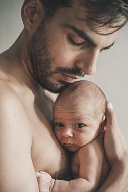 Bebekle evde sevgi dolu baba portresi. Sepya tonlu