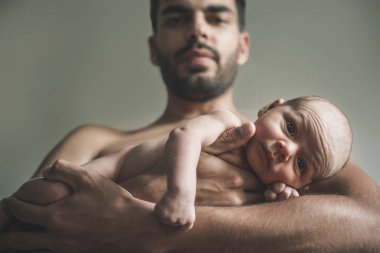 Bebekle evde sevgi dolu baba portresi. Sepya tonlu