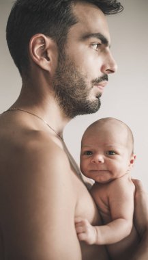 Bebekle evde sevgi dolu baba portresi. Sepya tonlu