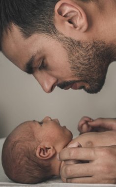 Bebekle evde sevgi dolu baba portresi. Sepya tonlu