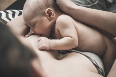 Yumuşak fotoğraf genç annesi bebeğini evde emzirme.