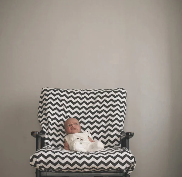 Cute newborn baby sitting in the big chair — Stock Photo, Image