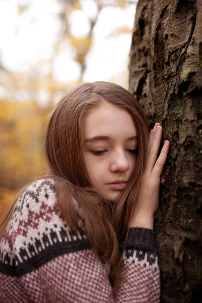 Jolie jeune fille appuyée main contre un arbre — Photo