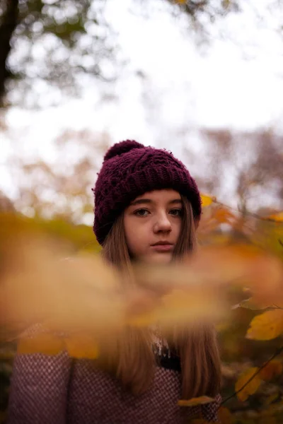 Hezká mladá dívka hledá přes listy — Stock fotografie