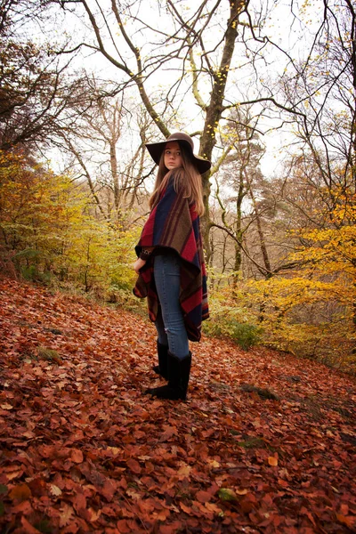 Молодая девушка-подросток, стоящая в лесу осенью — стоковое фото
