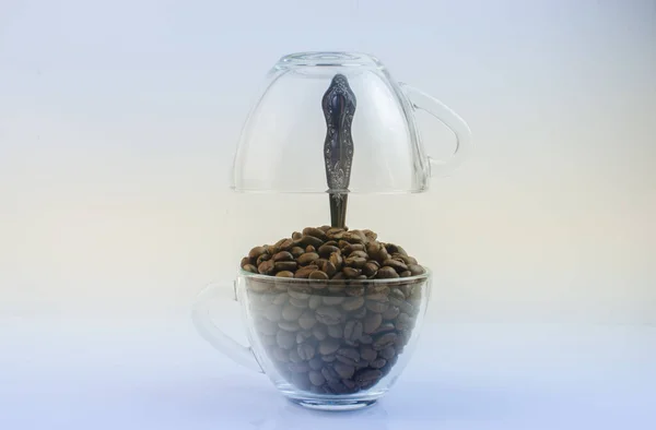 Grãos de café em canecas transparentes — Fotografia de Stock