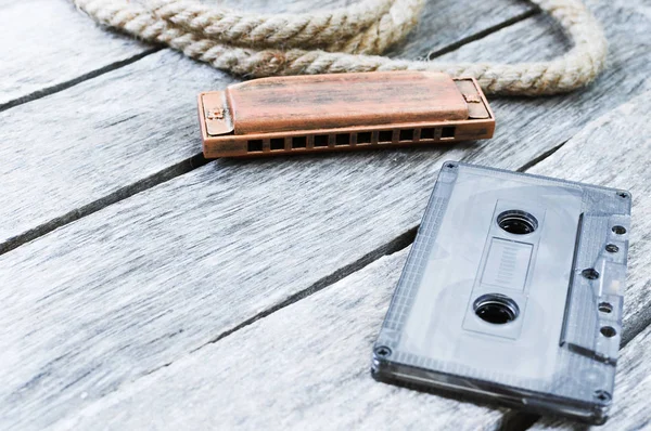 Harmonica and an old audio cassette tape — Stock Photo, Image