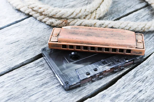 Harmonica and an old audio cassette tape — Stock Photo, Image