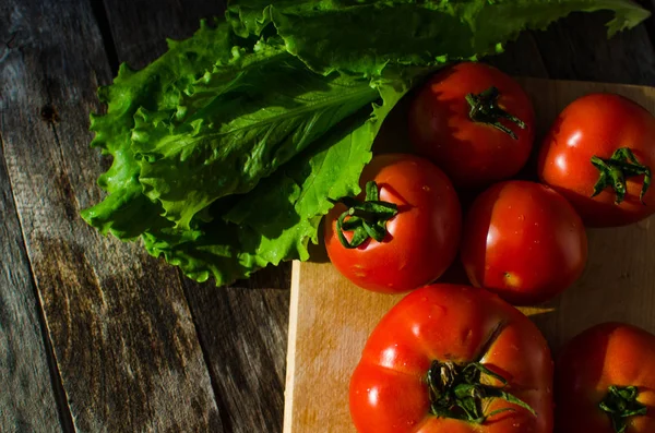 Tomates maduros em uma tábua de corte — Fotografia de Stock