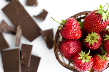 Hasır sepet içinde kırık çikolata, çilek