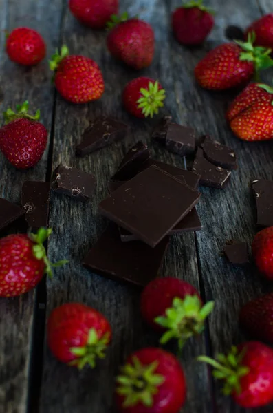 Strawberries and pieces of broken chocolate — Stock Photo, Image