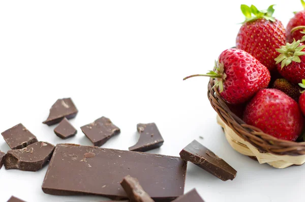 Σπασμένα σοκολάτα, φράουλες σε ένα καλάθι λυγαριά — Φωτογραφία Αρχείου
