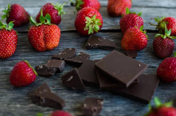 Morangos e pedaços de chocolate partido — Fotografia de Stock