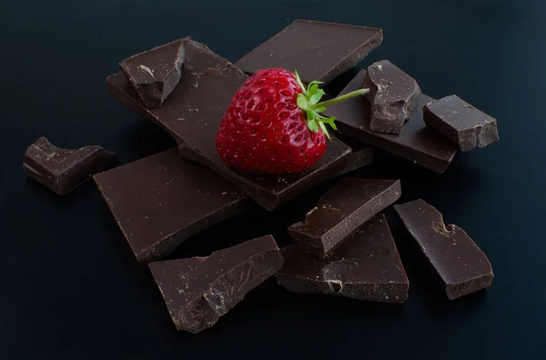 Een aardbei in gebroken chocoladerepen — Stockfoto