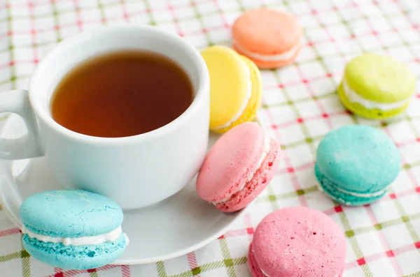 Une tasse de thé et un gâteau et un macaron — Photo